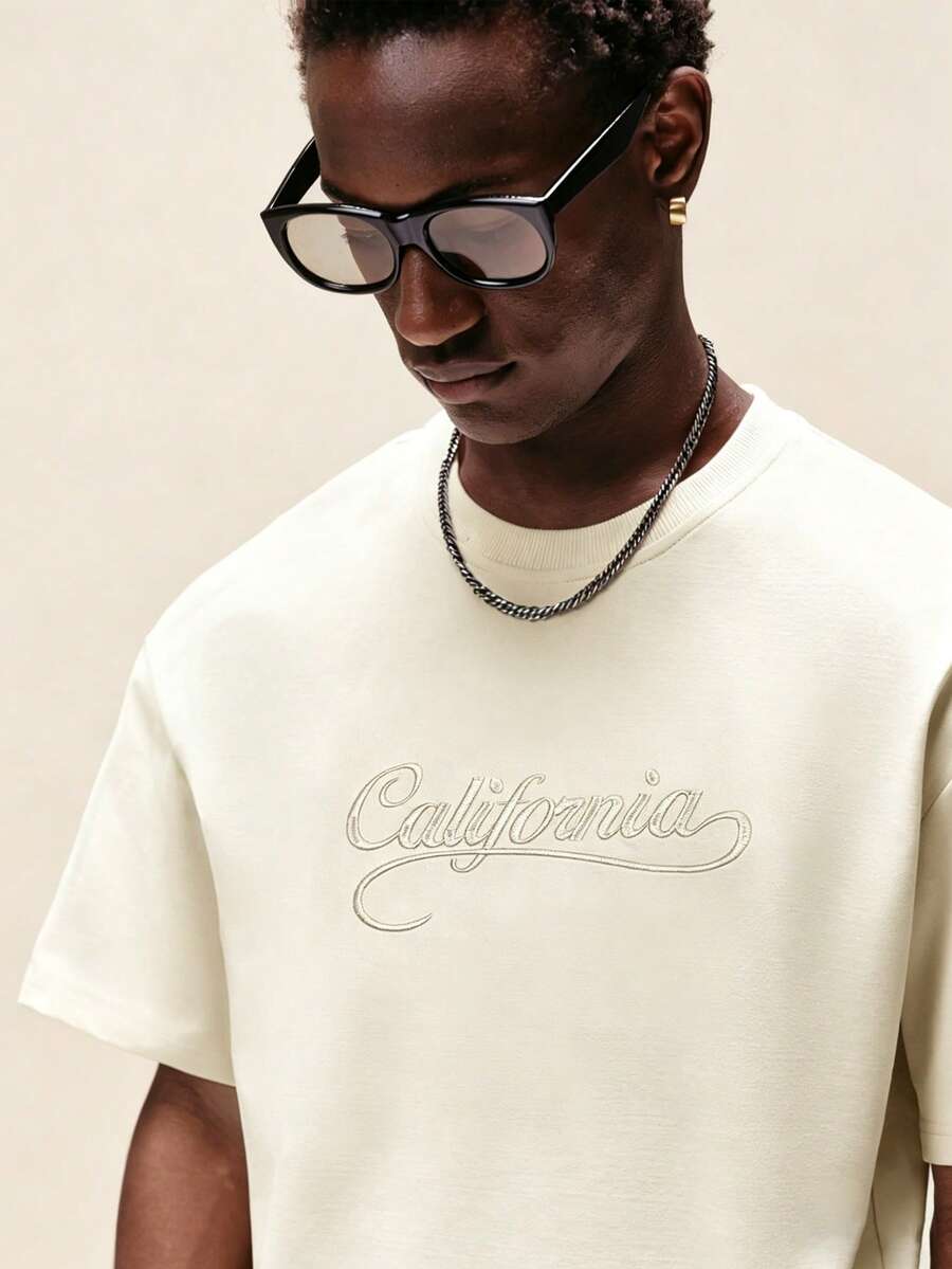 STYNVO Camiseta Branca Solta com Estampa de Letra, Ombros Caídos, Casual para Férias e Transporte, Moda de Rua, Verão